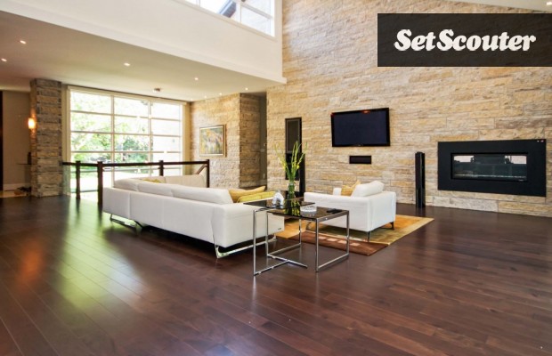 Lilliana's living room is bright and earthy with dark hardwood floors and a unique stone feature wall. The furniture is luxurious and the in-wall gas fireplace is a nice backdrop bonus.