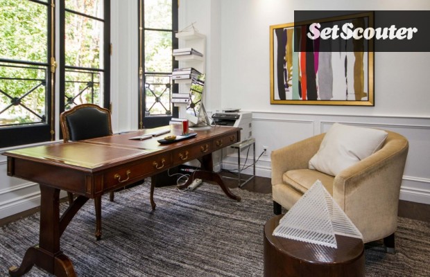 Paula's home office is charming and bright. The wall of windows behind the desk let in ample natural light while the white walls keep the space airy. The sleek wood desk is a unique twist on a traditional look.
