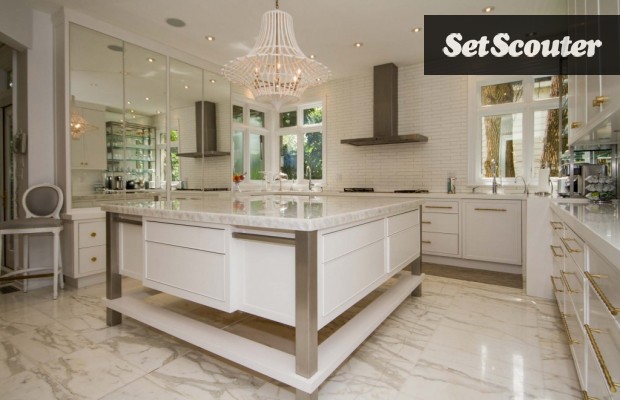 This spacious kitchen is crisp and modern. The mirrors, marble floors and decadent lighting give this space a luxurious feel. Paula's gourmet appliances and giant island complete this high-end look.