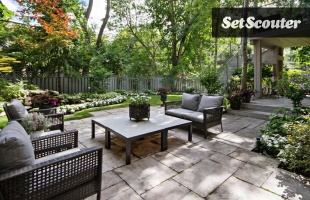 This outdoor seating space is a serene escape from the city. Paula's backyard is beautifully landscaped with flowers and a green lawn. The stairs leading up to the balcony allow for great overhead shots.