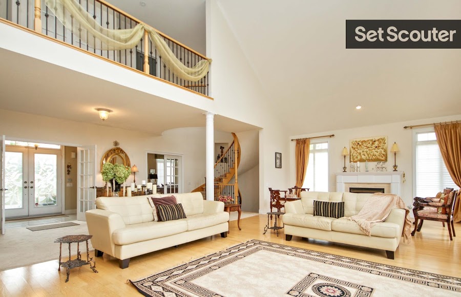 Entering the home reveals a lavish living space with 20-inch ceilings and cream leather sofas. Everything from the brass coloured drapes to the art above the fireplace was chosen with a look of luxury in mind. The room exudes elegance and charm that could belong to a rich yet modest family.