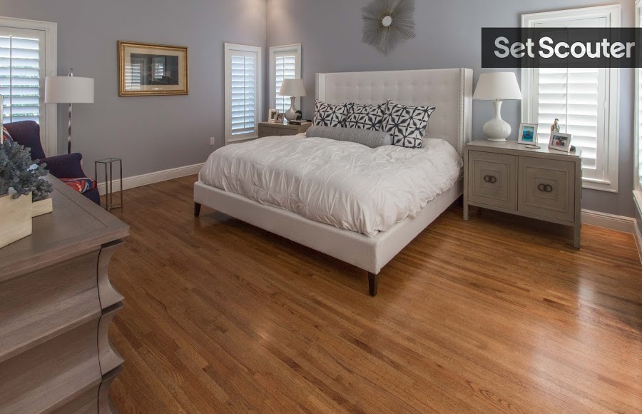 The master bedroom is warm and bright. Light blue walls, white baseboards and light hardwood floors are inviting and clean, complimenting Marianna's plush bed. Taupe dressers and large shutter blinds match the cottage feel throughout the rest of the home.