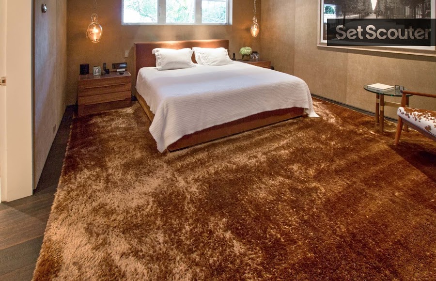 The master bedroom is elegant and luxurious. Covering the majority of the floor, a rich brown shag looks cool and comfy as the room’s focal point. This room embodies serenity and intimacy with its earthy tones, delicate glass reading lamps and clean white bedding.