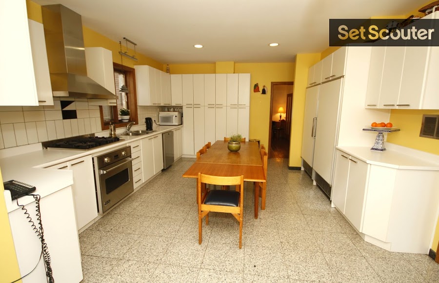 This kitchen has a bright and crisp look, where luminous warm walls complement the white cabinets and countertops perfectly. Adele’s kitchen beautifully mixes old with new decor, contrasting a vintage dining set with stylish, stainless steel finishes. This open kitchen has a classic charm that makes it the perfect setting for an retro informercial or cooking scene!