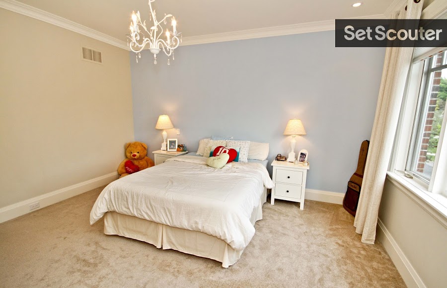 Linda's family home includes a minimalist yet dainty upstairs bedroom. With a lilac accent wall and delicate chandelier, this room is feminine, romantic and perfect to suit a young adult or teenage character.