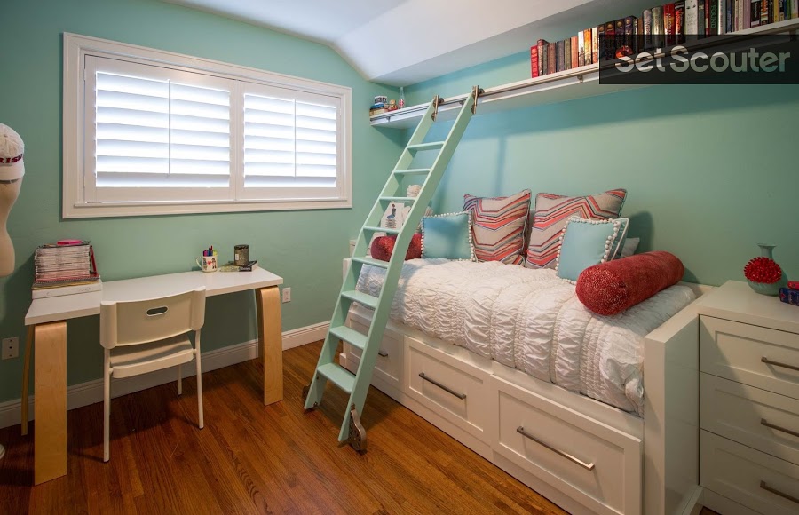 A child’s room painted in turquoise is funky and sweet. A rolling library ladder makes reaching books on a high shelf as easy as ABC. From the playful colour scheme, to the minimalist desk, and row of books, this room would be well suited to a young character full of imagination and interest in learning.