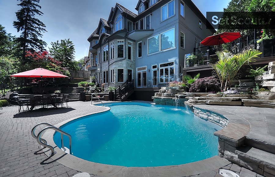 Behind this massive house lays a hidden oasis. Cobblestone surrounds an underground pool, just below a large, furnished patio. While, the patio furniture remains modest, it allows the natural beauty of the surrounding pine trees to take centre stage.