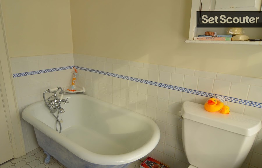 This children's bathroom is quaint with simple ceramic tiles and a comfy clawfoot tub. Small additions like the rubber ducks give the bathroom a lived-in feel, already dressed for a family-oriented production!