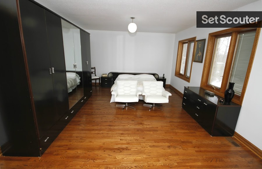This spacious master bedroom is elegant, combining comfort and style in its design. The sleek black dresser contrasts the clean white furniture beautifully, while the wood trimmings add warmth to this stunning bedroom. High ceilings and an open design allow for various angles and extreme wide shots for production!