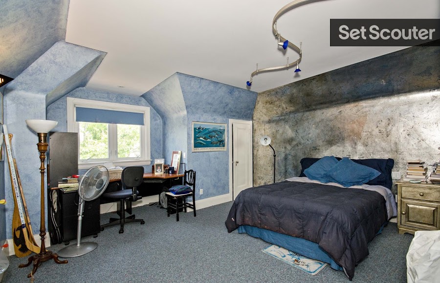 This stylish bedroom is highlighted by it’s unique structure and design. Featuring gradient blue-to-black walls, Rhonda has decorated this bedroom with some great, dark furnishing to match with touches of youthful charm. A desk by the large window creates the perfect production backdrop for any student getting home to hit the books.