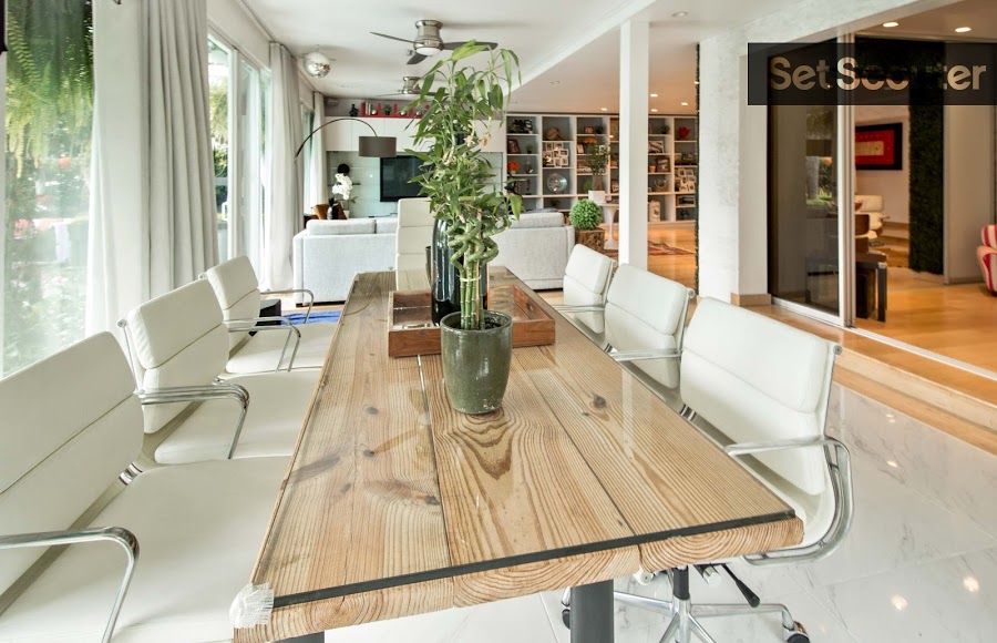 The dining area is filled rustic charm and personality, featuring a hand made wood table and cushy, white swivel chairs. This fresh space opens up outside and invites natural light to shine through its floor-to-ceiling windows.