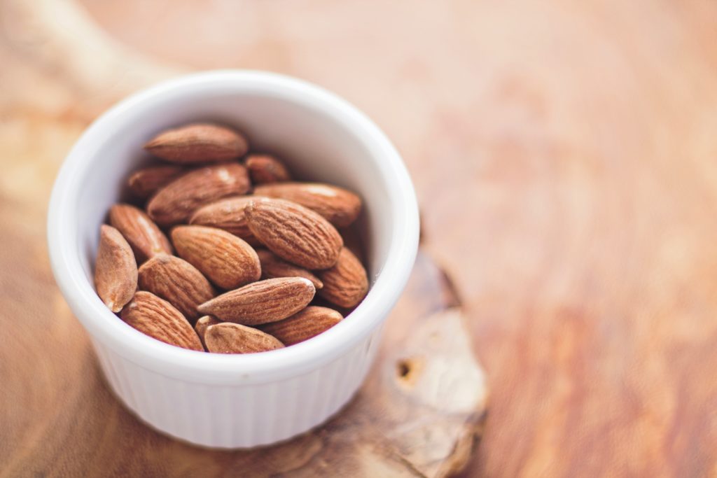 Enjoy a healthy snack on your breaks throughout the day to protect your mental health on a film set. Pictured:  a bowl of salted almonds.